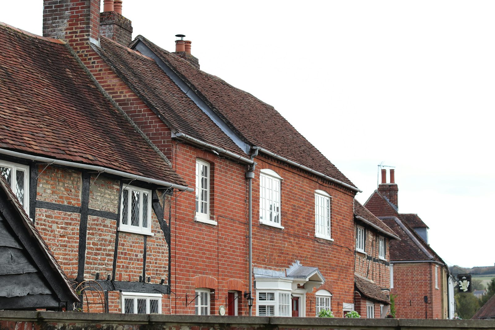 Row of traditional British brick and timber terraced houses with newly finished tiled roofs