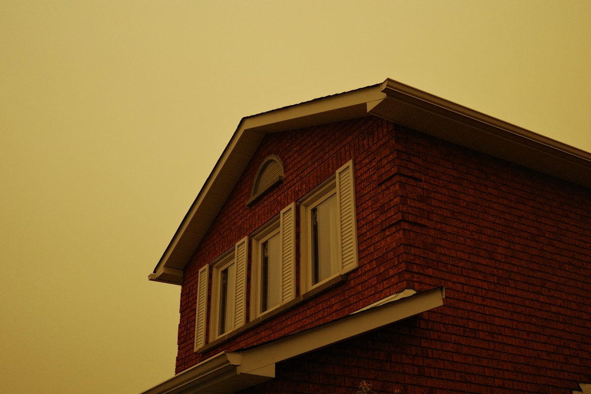 Repaired dormer and eaves detail on a British brick property at golden hour